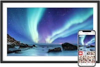 a framed photo of the aurora borealis with a phone next to it